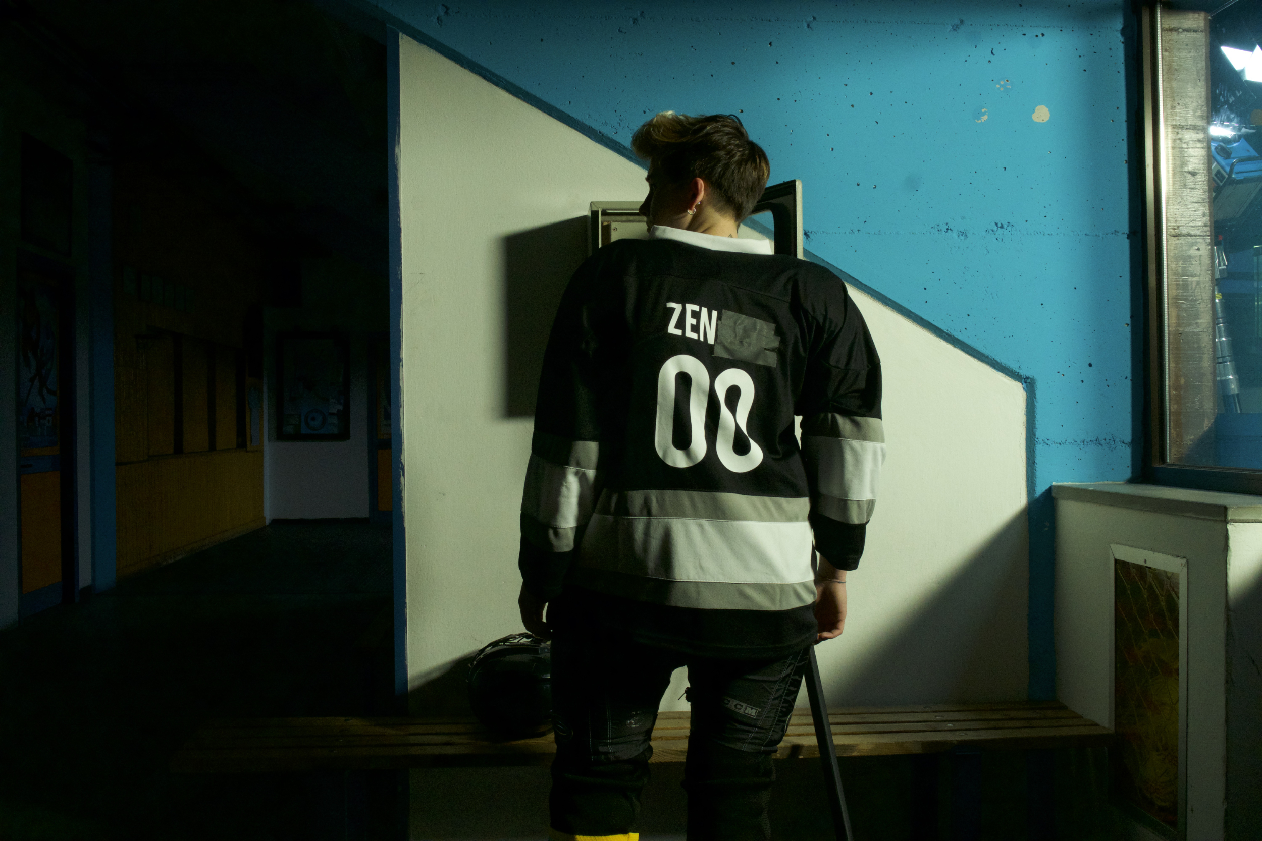 protagonista del film zen sul ghiaccio sottile visto da dietro in uno spogliatoio con la divisa da hockey